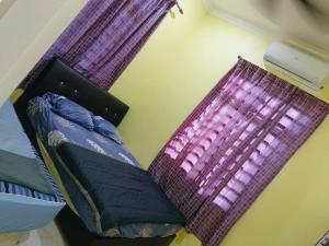 two pillows sitting on a bed next to a window at Rumah Kuning Homestay in Bachok
