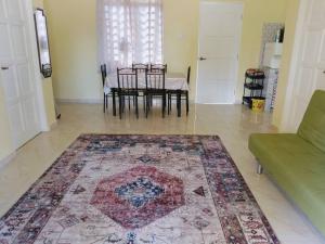 a living room with a table and a rug at Rumah Kuning Homestay in Bachok