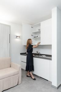 a woman in a black dress standing in a kitchen at By THE LAKE in Muralto