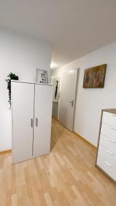 an empty room with a white cabinet and two doors at Charmantes Studio in Solothurn