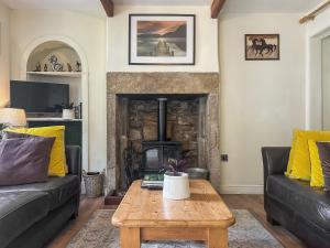 a living room with a table and a fireplace at Emily's Cottage in Hebden