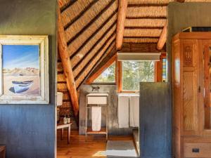a bathroom with a wooden ceiling and a window at Mountain Cabin private hot tub and swimming pool in Wolseley
