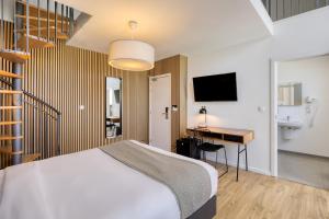 a bedroom with a bed and a desk and a television at Beverly Hills Hotel in Brussels