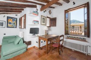 a living room with a desk and a bed and a window at Ca Hado Xucla in Valldemossa