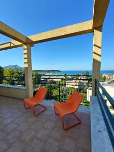 two orange chairs on a balcony with a view at Villa Cristina in Casteldaccia