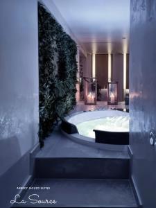 a bathroom with a large tub with a green wall at Suites avec Jacuzzi Privé & Terrasse - Vieille Ville d'Annecy in Annecy +28 photos