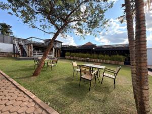 a group of chairs and a table in the grass at Elite Apartments Masaka in Kigali