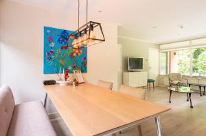 a dining room with a table and a living room at De Vlinderstruik | 4 persons in Gasselte