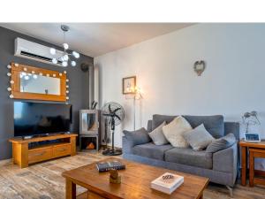 a living room with a couch and a tv at The Summer Haven in Polis Chrysochous