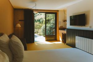 ein Schlafzimmer mit einem Bett und einer Glasschiebetür in der Unterkunft Le Barn in Bonnelles