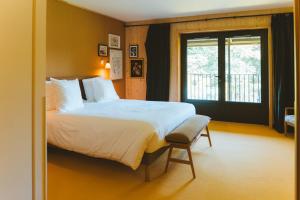 ein Schlafzimmer mit einem großen Bett und einem Fenster in der Unterkunft Le Barn in Bonnelles