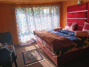 a bedroom with a large bed and a window at Hotel alpine resort pahalgam in Pahalgām