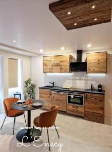 a kitchen with a table and chairs in a room at Suites avec Jacuzzi Privé & Terrasse - Vieille Ville d'Annecy in Annecy