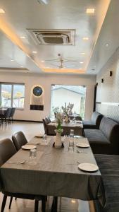 a dining room with a table and a couch at Status Club in Hardoī