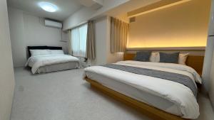 a bedroom with two beds and a window at attomi hostel 2 in Sapporo