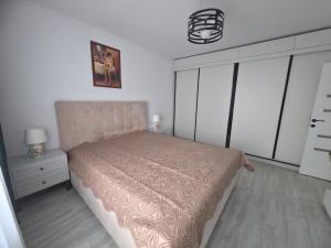 a bedroom with a bed and a dresser and a lamp at The Cozy Velvet in Ocna-Mureşului