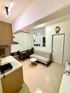 a kitchen and living room with a couch and a table at The JOYful Stay in Mactan Island