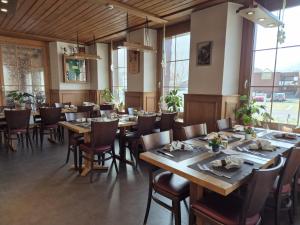 a restaurant with wooden tables and chairs and windows at Gasthof Hirschen in Wilderswil in Wilderswil