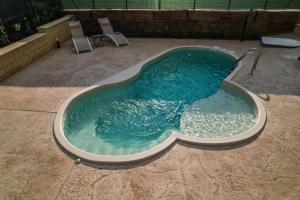 a jacuzzi tub with chairs in a backyard at Casale Sammartano - Appartamenti con piscina comune in Ummari