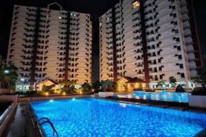 a large swimming pool in front of two large buildings at The JOYful Stay in Mactan Island +4 photos