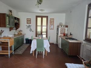 a kitchen with a table with green cabinets at Oasi della Calvana in Vaiano +13 photos