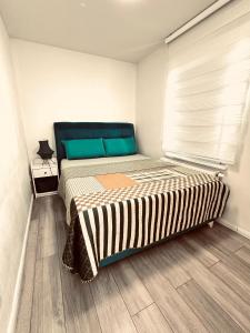 a bedroom with a large bed with green pillows at Apartment klein, fein, ruhig und gemütlich in Bochum