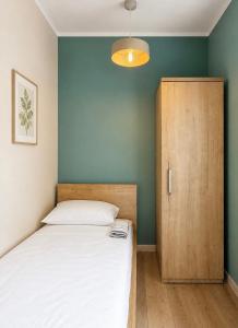 a bedroom with a bed and a wooden cabinet at Apartament Contra II in Wodzisław Śląski
