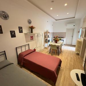 a bedroom with two beds and a dining room with a table at Affittacamere Nel Cuore di Faenza in Faenza