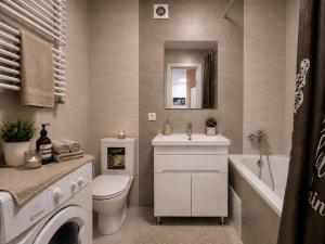 a bathroom with a sink and a toilet and a bath tub at Апартаменти 2-кім Тарнавського in Ternopil +12 photos