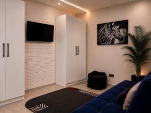 a living room with a blue couch and a tv at Апартаменти 2-кім Тарнавського in Ternopil