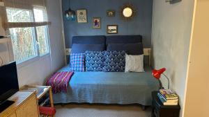 a bedroom with a blue bed with pillows and a mirror at El Moll Grec in L'Escala
