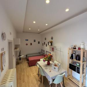 a living room with a table and a bed at Affittacamere Nel Cuore di Faenza in Faenza