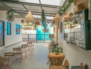 a restaurant with tables and chairs in a room at Manzil Anilao B&B in Mabini