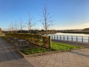 a row of park benches next to a body of water at Great for commuting, budget friendly apartment in Dalmuir