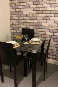 a dining room table with two chairs and plates on it at Great for commuting, budget friendly apartment in Dalmuir +4 photos