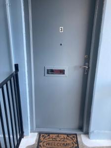 a blue door with a sign on it next to a staircase at Great for commuting, budget friendly apartment in Dalmuir