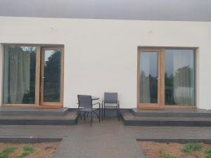 a patio with two windows and a table and chairs at Miskant Apartamenty in Stary Karwno +6 photos