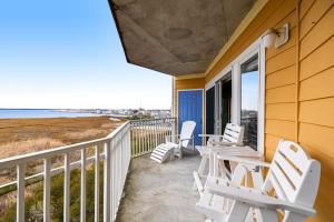 a porch with two chairs and a table on the side of a house at Playa Flamingo #302 in Ocean City