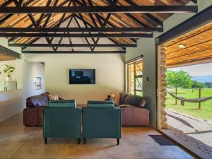 a living room with a couch and a tv at Wild Olive Cottage with Hot tub in Wolseley