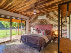 a bedroom with a brick wall and a bed at Wild Olive Cottage with Hot tub in Wolseley +27 photos