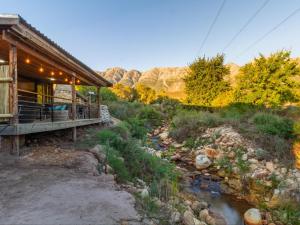 a river in front of a building with a river gmaxwell gmaxwell gmaxwell at Wild Olive Cottage with Hot tub in Wolseley