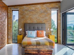 a bedroom with a bed and a brick wall at Mountain Bungalow private hot tub&swimming pool in Wolseley