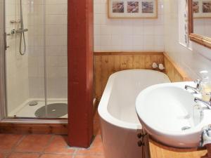 a bathroom with a tub and a sink and a shower at Gareside Lodge in Rhu