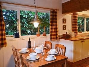 a kitchen with a wooden table with chairs and a dining room at Gareside Lodge in Rhu