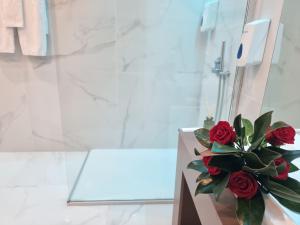 ein Strauß roter Rosen im Badezimmer in der Unterkunft Motel Século in Lousada