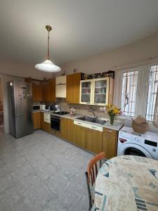 a kitchen with wooden cabinets and a sink and a table at Silver View House in Theologos