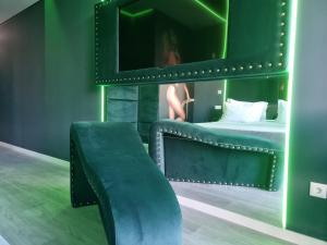 ein grünes Zimmer mit zwei Betten und einem Spiegel in der Unterkunft Motel Século in Lousada