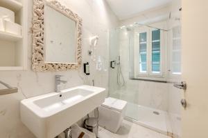a white bathroom with a sink and a shower at HNN Luxury Suites in Genoa +84 photos