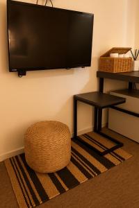 a flat screen tv hanging on a wall with a stool at Hotel Amy in Pup'yŏng-yŏk