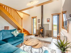 a living room with a blue couch and a wood stove at The Larches - Uk46804 in Culbokie
